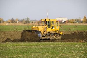 le Jaune tracteur avec attaché grédérom fait du sol mise à niveau. photo