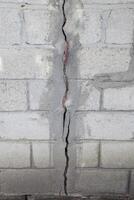 une fissure dans le béton mur. le destruction de le mur de le gris blocs photo