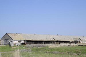 vieux ferme bâtiment. qui fuit ardoise toit sur le ferme photo