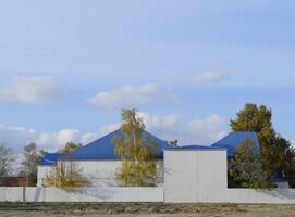 le bâtiment avec bardage et bleu métal-plastique toit fabriqué de ondulé fer. photo