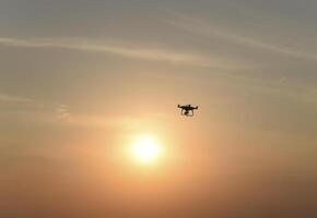 drone silhouette contre le Contexte de le le coucher du soleil photo