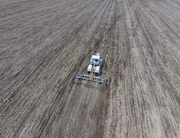 cultivation de sol pour le semis de céréales. tracteur charrues le sol sur le champ photo