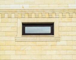 Contexte de Jaune brique et les fenêtres. mur de Jaune briques avec une Plastique la fenêtre. le texture de le mur photo