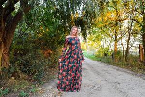 Dame en dessous de une gros saule arbre. femme dans une robe. photo