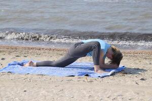 fille les pratiques yoga par le mer. exercice gymnastique dans le Frais air par le mer. photo