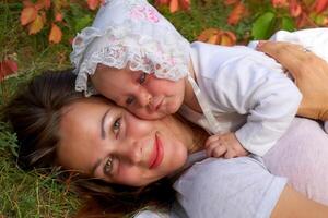 Jeune jolie mère avec une mignonne Sein nouveau née bébé dans une ensoleillé forêt photo