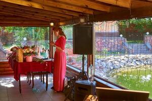 mignonne anniversaire, mariage et un événement hôte dans rouge écarlate attendre pour invités photo