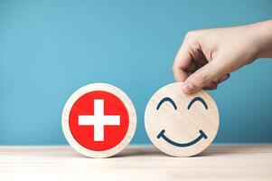 concept de soins de santé pour santé évaluation, annuel santé examen. emoji montrant très bien niveau de la satisfaction avec médical symboles sur circulaire pièce de bois photo