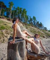 deux Jeune femmes dans rétro maillots de bain par le mer photo