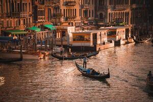 le coucher du soleil gondoles iconique vénitien bateaux sur grandiose canal à crépuscule dans chaud tons photo