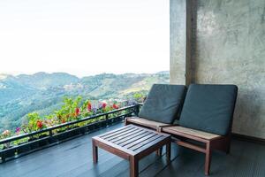 chaise sur balcon avec fond de colline de montagne photo
