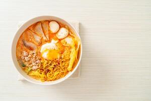 nouilles aux œufs avec porc et boulettes de viande dans une soupe épicée photo
