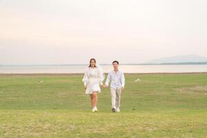 heureux jeune couple asiatique en vêtements de mariée et de marié photo