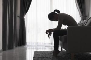 Jeune déprimé femme, national et râpé violence, battu et violé séance dans le coin, international journée pour le élimination de la violence contre femmes. photo