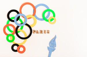 Jeux olympiques, Paris, France, été, 2024. multicolore anneaux autour le texte et une flamme sur une lumière photo