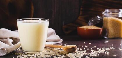 sans lactose riz Lait dans une verre et riz céréale sur le table la toile bannière photo