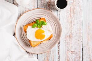 croquer Madame sandwich avec jambon, fromage et Oeuf sur une assiette sur le table Haut vue photo