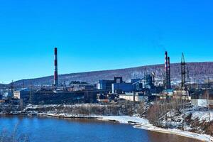 hiver industriel paysage avec un vieux du Coca et chimique plante sur le rivière banque photo