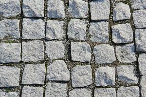 Contexte - fragment de un vieux trottoir pavé avec granit pavage des pierres photo