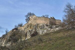 vue de le ruines de un ancien forteresse sur une rocheux sommet de la colline photo