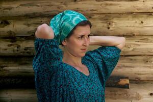 portrait de une femme dans une traditionnel paysan robe et une foulard contre le Contexte de une Journal mur photo