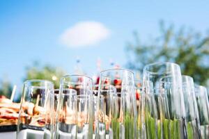 buffet dans le ouvert air - vide des lunettes sur le Contexte de du froid collations contre le ciel photo