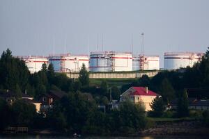 pétrole espace de rangement sur une colline au dessus une village sur le rive dans permanente, Russie photo