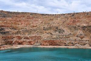 vieux calcaire carrière avec une bleu Lac à le bas photo