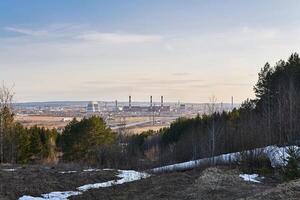 industriel paysage dans de bonne heure printemps avec une Puissance station dans le vallée et le chauffage principale de premier plan de il photo