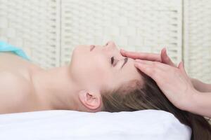 magnifique Jeune femme avoir faciale massage dans le spa salon, fermer portrait, côté vue photo