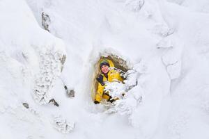 femme voyageur posant dans une Naturel la grotte dans une neigeux Roche photo
