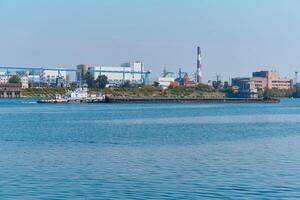 remorqueur pousse sec masse cargaison barge sur le rivière passé le industriel paysage photo