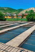 poisson ferme dans une Montagne vallée avec aquaculture des cages et en bois bâtiments photo