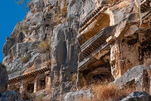 fragment de célèbre complexe de Roche tombes dans le ruines de myra de lycie avec reliefs sur le falaise photo