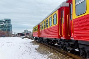 passager train sur une étroit jauge chemin de fer contre le Contexte de le ville photo