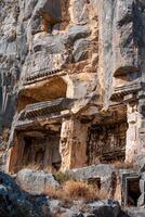 ruines de une rocheux nécropole avec tombes sculpté dans pierre dans myra lycien photo