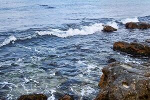 mer vagues dans le zone de rocheux littoral proche en haut photo