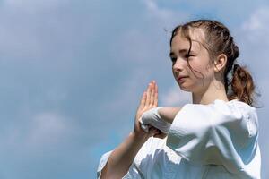 adolescent fille formation karaté kata en plein air, salutations oss photo