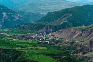 aérien vue de une village dans une Montagne vallée parmi jardins et des champs photo