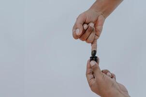 encré pinky doigt. violet encre taches de de l'électeur doigt fournit preuve de le présidentiel élection dans Indonésie. isolé sur blanc Contexte. copie espace. photo