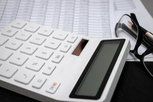 financier les documents et blanc calculatrices sur noir en bois bureaux photo