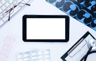 médecins lieu de travail avec numérique tablette avec endroit pour texte sur blanc tableau. flatlay composition. Haut voir. médical concept. photo