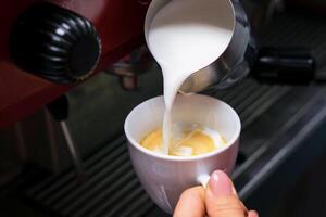 barista fille verse fraîchement Lait dans à café. fermer. sélectif se concentrer. photo