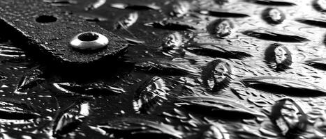 ai généré macro coup de brillant l'eau gouttelettes sur une texturé noir perforé métal surface photo