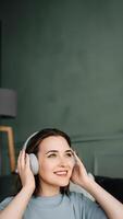 une souriant Jeune âge moyen femme portant sans fil écouteurs écoute à musique. musical bonheur. âge moyen femme embrassement joie par sans fil écouteurs. rythmique échapper photo
