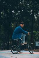 Jeune Beau barbu homme prise une Pause tandis que en voyageant le ville avec le sien vélo en utilisant le sien numérique tablette à la recherche une façon pensivement photo