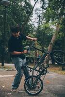 Jeune Beau barbu homme prise une Pause tandis que en voyageant le ville avec le sien vélo en utilisant le sien numérique tablette à la recherche une façon pensivement photo