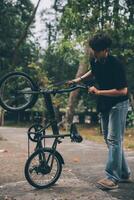 Jeune Beau barbu homme prise une Pause tandis que en voyageant le ville avec le sien vélo en utilisant le sien numérique tablette à la recherche une façon pensivement photo