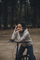 content asiatique Jeune femme marcher et balade vélo dans parc, rue ville sa souriant en utilisant bicyclette de transport, éco amical, gens mode de vie concept. photo