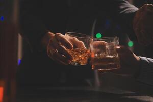 fête nuit, verser whisky dans une verre. donner à copains qui viens à célébrer photo